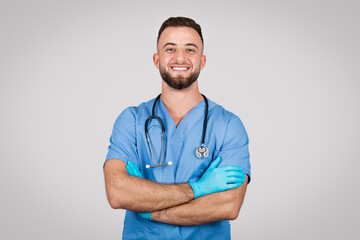 Confident european doctor man with crossed arms and smiling at camera - obrazy, fototapety, plakaty