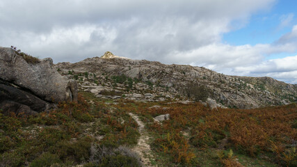 Fototapeta na wymiar Path through mountain landscape of granite rocks with green vegetation, Peneda-Geres National Park, Vilar da Veiga, Portugal