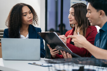 Fototapeta premium Group of diverse business people discussing a project in a meeting for analysis graph company financial.