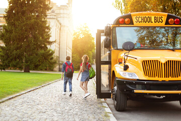 Group of children getting out the yellow retro school bus, - obrazy, fototapety, plakaty