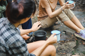 People Trekking Group Boil Water and Check Water Temperature by Hand while Holding the Cup. Boil...