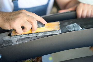 Skilled auto detailer buffing vehicle body part using tool