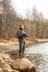Naklejka premium fisherman fishing on the river bank, Fishing rod, spinning
