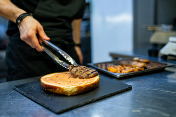 chef hand cooking big large cheese burger on restaurant kitchen. step by step