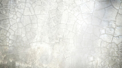 A picture of a cracked cement floor inside a building. The edge of the picture is dark.