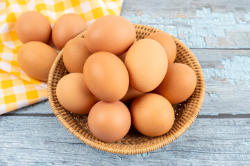 Organic chicken eggs in basket with tablecloth.