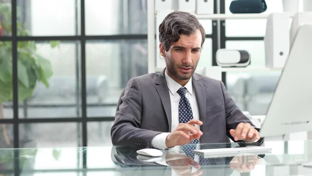 Surprised businessman holding banknote near computer in office