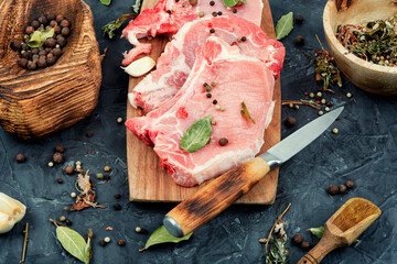 Pork chops with ingredients for cooking.