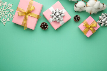 Christmas composition. Pink gifts, gold decorations on mint background. New year concept.