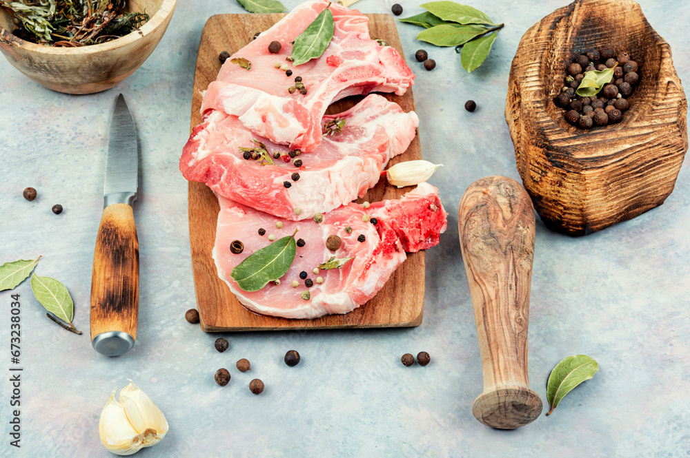 Sticker raw pork steak on a wooden board.