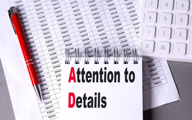 ATTENTION TO DETAILS text on notebook with pen, calculator and chart on grey background