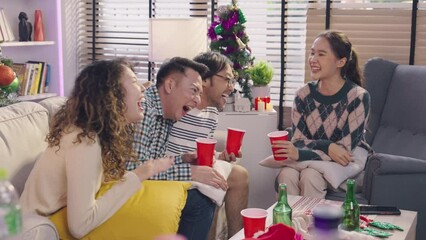Group of Asian friends having fun chatting at a house party friend reunion greeting and smiling with christmas tree behind party with friend concept