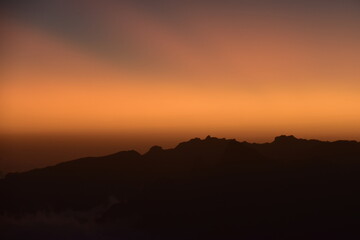 Fototapeta premium Orange sky at a stunning sunset above the clouds on Mount Kilimanjaro in Tanzania, Africa