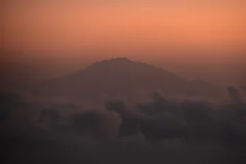 Photo sur Plexiglas Kilimandjaro Orange sky at a stunning sunset above the clouds on Mount Kilimanjaro in Tanzania, Africa