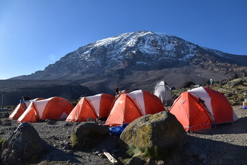 Camping in an orange tent on the Lemosho route while trekking Mount Kilimanjaro in Tanzania © ChrisOvergaard