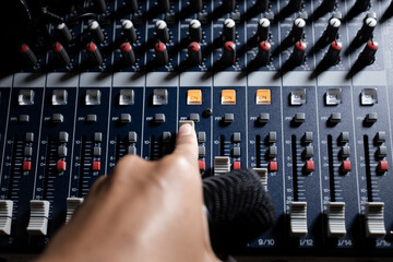 Men's hands are controlling the console of a large hi-fi system. Sound equipment. Control panel of...