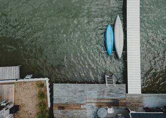 Aerial view of a wooden dock extending out into the water with two boats docked near