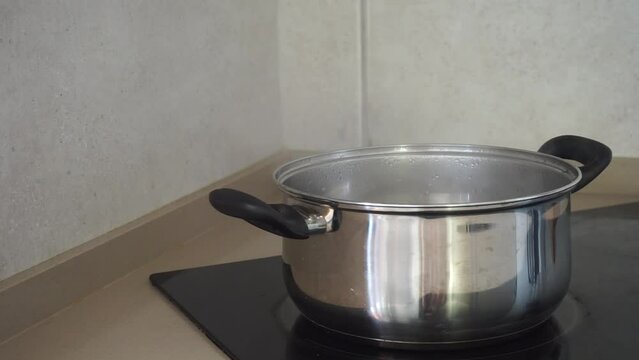 A pot of boiling water with steam on  an electric stove in the kitchen.Preparing food concept.