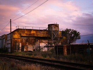 Fototapeta na wymiar Old rusty building next to train tracks in a rural area