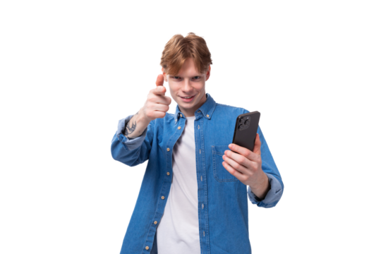 young handsome european man with copper hair dressed casually takes a selfie on the phone