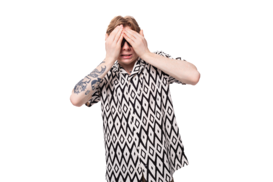 European young man with golden hair and a tattoo on his arms, dressed in a summer black and white shirt, closed his eyes to hide his face - Powered by Adobe