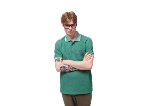portrait of a young confident stylish red-haired guy in a green t-shirt and brown pants