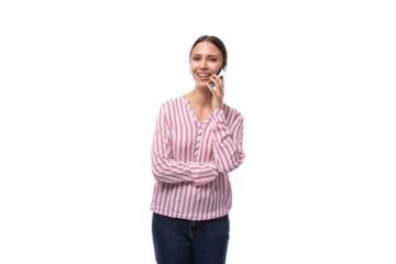 a young smart European woman with black hair gathered in a ponytail is dressed in a red and white striped blouse speaks on the phone