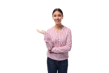 young smart caucasian woman with black hair gathered in a ponytail dressed in a striped blouse stands thoughtfully