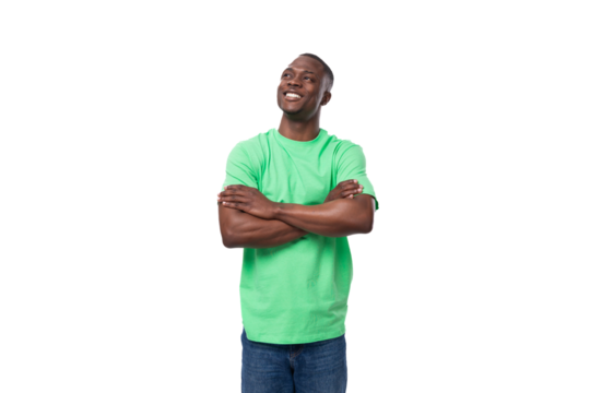 young handsome african man in light green t-shirt and jeans on white background with copy space