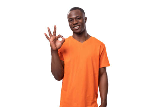 young cheerful african man in orange t-shirt smiling broadly on white background