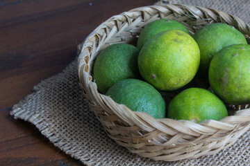 several whole limes in a bamboo basket