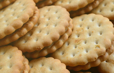 Detailed picture of round sandwich cookies with coconut filling. Background image of a close-up of several treats for tea