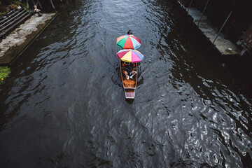 Wooden boats busy ferrying people at Amphawa floating market A traditional popular method of buying...