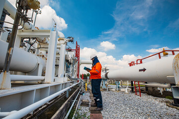 Naklejka premium Male worker inspection at steel long pipes and pipe elbow in station oil factory during refinery valve of visual check record pipeline oil and gas