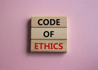 Code of ethics symbol. Concept words Code of ethics on wooden blocks. Beautiful pink background. Business and Code of ethics concept. Copy space.