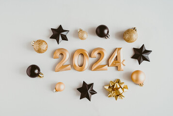 Greeting card - happy new year with numbers 2024 and golden and black Christmas balls decorate on light background.