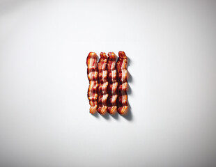 Aerial View of Neatly Arranged Bacon Rashers on a White Background