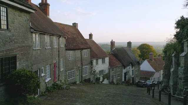 Gold Hill Shaftesbury.  Location of iconic Hovis Bread commercial by Ridley Scott. Evening sunshine on a summers day, steep cobbled street in England.   Drone tracks up the hill. No. 2 of a set of 6.