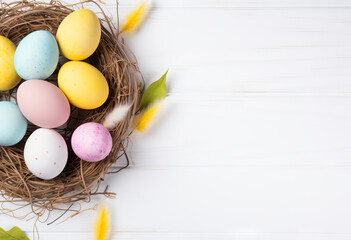 Colorful easter eggs in nest on white table background with copy space top view