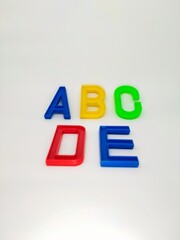 Colorful plastic letters with the word ABCDE on a white background
