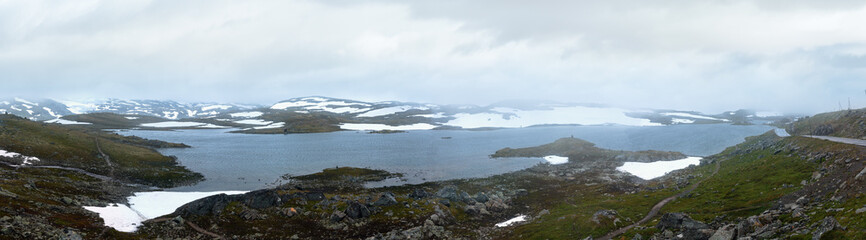 Dense fog and summer mountain landscape with lake and snow (Norway, not far Nigardsbreen glacier). Panorama.