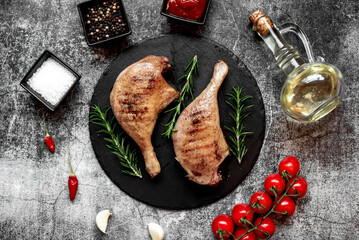 Grilled duck legs on a stone background
