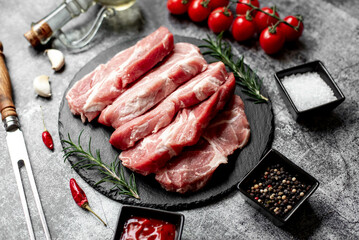 raw pork steaks on stone background