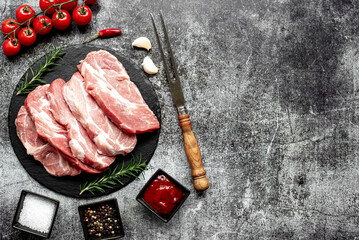 raw pork steaks on stone background with copy space for your text - obrazy, fototapety, plakaty