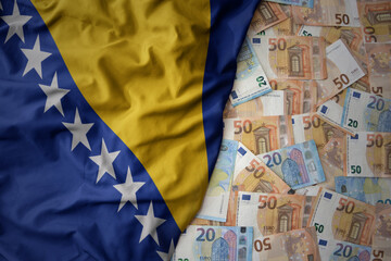 colorful waving national flag of bosnia and herzegovina on a euro money background. finance concept - obrazy, fototapety, plakaty