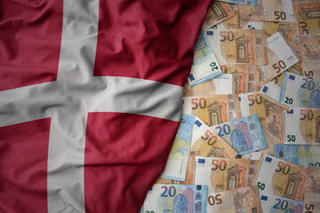 colorful waving national flag of denmark on a euro money background. finance concept