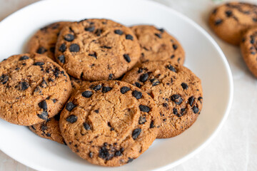 Chocolate cookies on a plate with spruce branches on the table. Dark chocolate cookies on a plate, Christmas cookies chocolate cinnamon sweet dessert holiday treat new year and christmas food