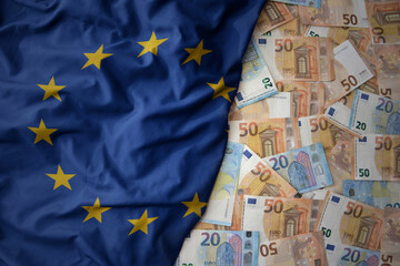 colorful waving national flag of european union on a euro money background. finance concept - obrazy, fototapety, plakaty