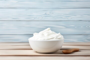 Fototapeta na wymiar Fresh homemade Greek yogurt in a ceramic bowl on a white wooden background with room for adding text