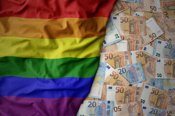 colorful waving rainbow gay pride flag on a euro money background. finance concept